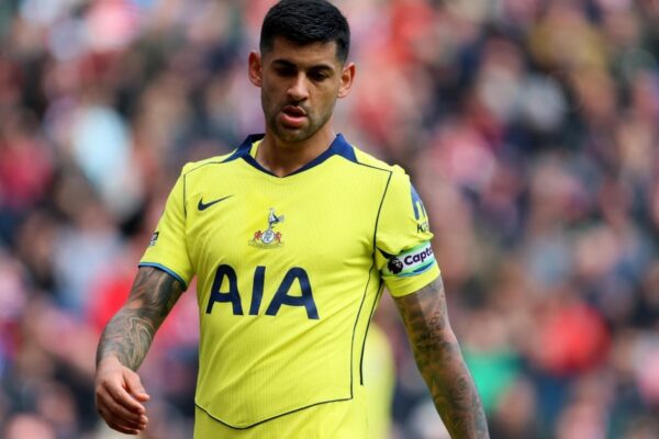 Cristian Romero avec Tottenham sur une pelouse de football.