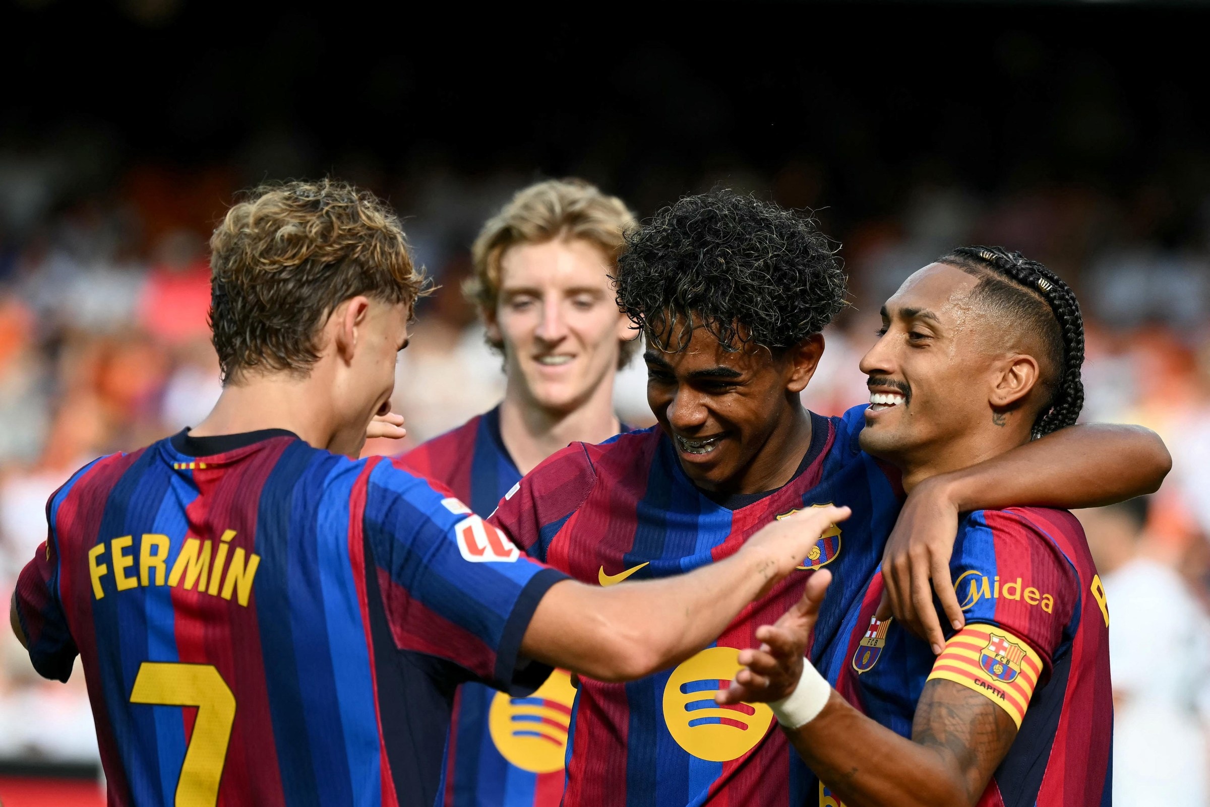 Barcelona’s Brazilian forward #11 Raphinha (R) celebrates with Barcelona’s Spanish forward #10 Lamine Yamal and Barcelona’s Spanish midfielder #07 Fermin Lopez (L) scoring his team’s third goal during the Spanish league football match between Valencia CF and FC Barcelona at Mestalla Stadium in Valencia on September 6, 2026. (Photo by JOSE JORDAN / AFP via Getty Images)