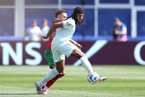 Jules Koundé portant le maillot du Barça sur un terrain de football.