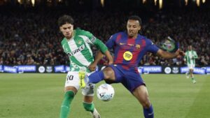 Raphinha sous le maillot du Barça sur un terrain de football.